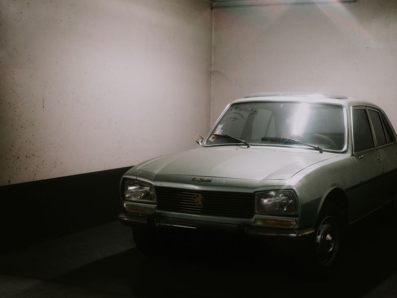 A vintage sedan parked in the corner of a garage