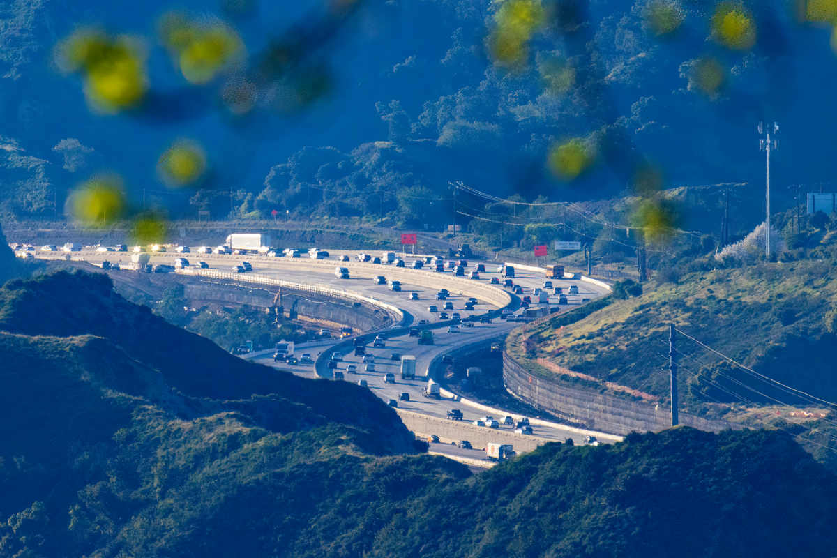 Aerial view of a bustling highway curving through mountain range