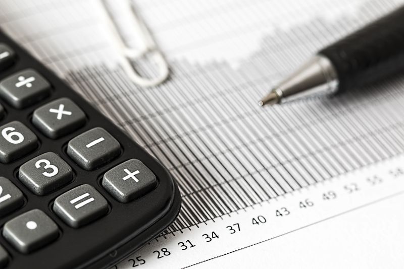 Close-up of a calculator and pen on a bar graph