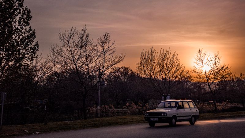 A vintage car traveling on a scenic road