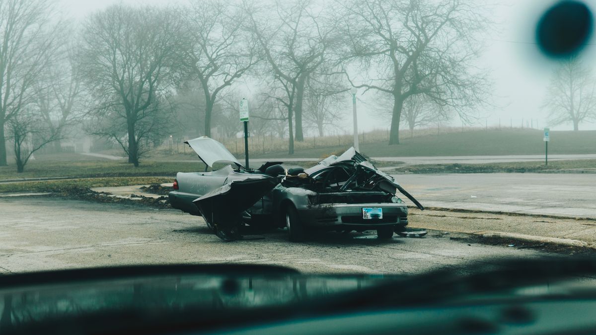 A damaged car on a foggy street